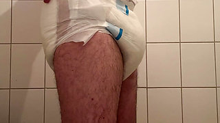 Diaper boy wearing a full diaper under his suit at work