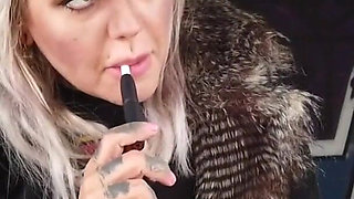 Blonde lady smokes an electronic cigarette