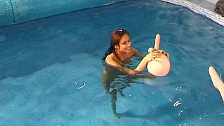 Two funky naked teens play with rubber sex dolls in swimming pool