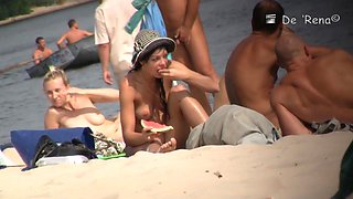 Pretty chick with natural boobs eating watermelon lying on the beach