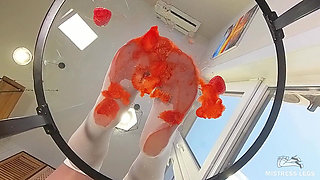 My Nylon Feet Squeezing Strawberry Juice on a Glass Table