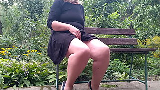 Lustful MILF pissing while sitting on a bench