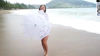 Brown haired girl taunts on a sunny beach