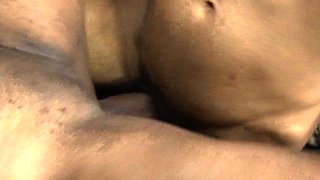 In a kitchen a sexy brunette playing with her big boobs