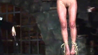 Blonde Girl Has Weights Attached to Her Feet and Is Hoisted up for Whipping